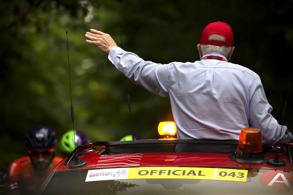 Tour of Britain 2022 - The race commissaire appears from the sunroof of the red race car ready to start the race