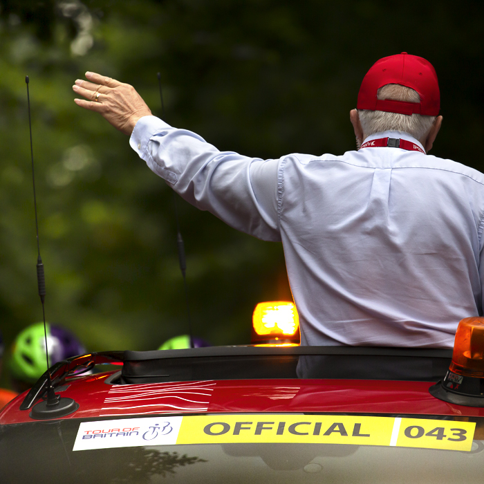 Tour of Britain 2022 - The race commissaire appears from the sunroof of the red race car ready to start the race