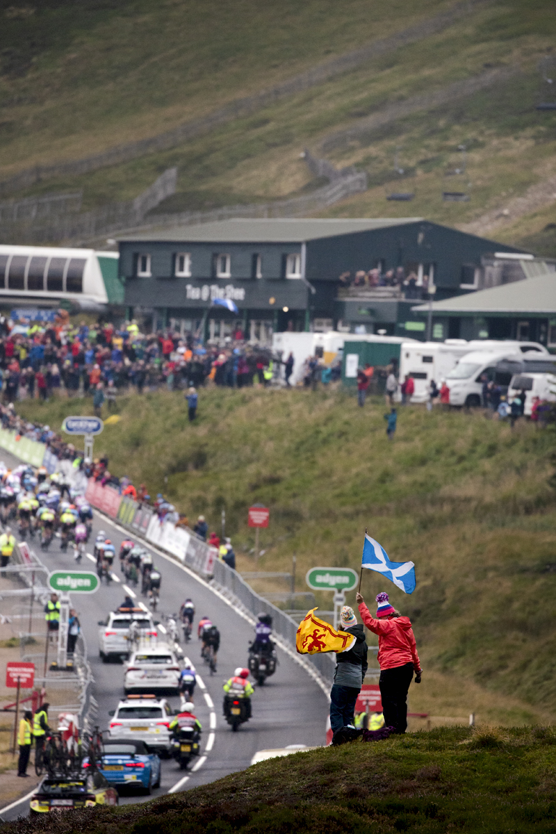 Tour of Britain 2022 - Two fans wave Scottish Flags from a hill top as they view the race approaching the finish line at Glenshee Ski Centre