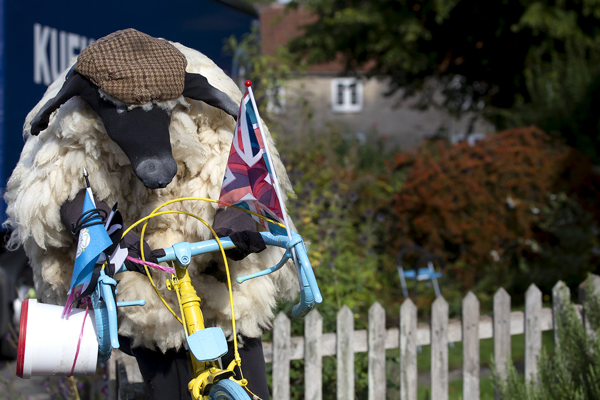 Tour of Britain 2022 - Fan art of a sheep wearing a flat cap holding a Yorkshire flag in Helmsley