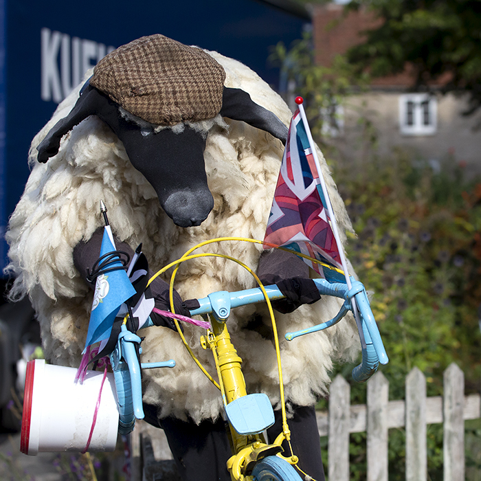 Tour of Britain 2022 - Fan art of a sheep wearing a flat cap holding a Yorkshire flag in Helmsley