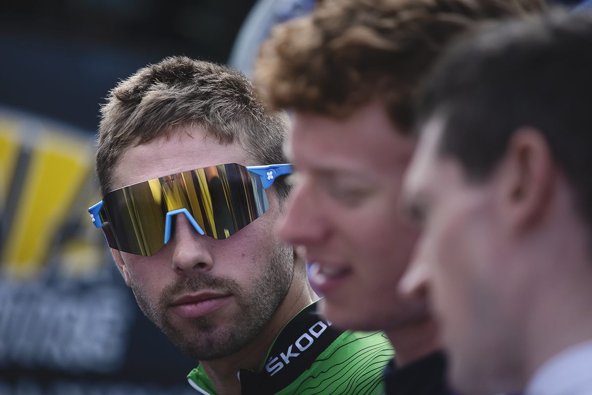 Tour of Britain 2022 - Jacob Scott of WiV SunGod in sunglasses looks past his team mates towards the camera