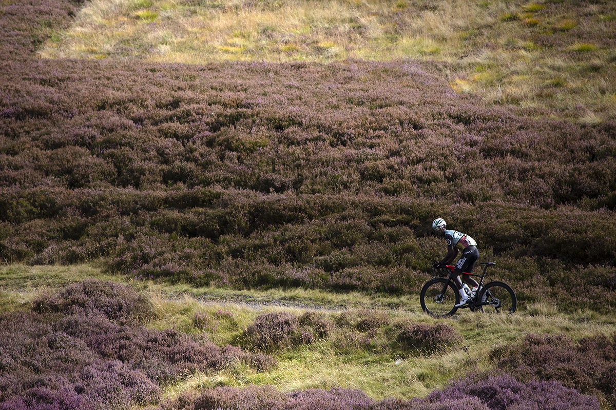 Tour of Britain 2022 - Nahom Zerai of Team Qhubeka climbs through the heather clad moorland up the King of the Mountains climb at Mainslaughter Law in the Scottish Borders on Stage 2 of the race