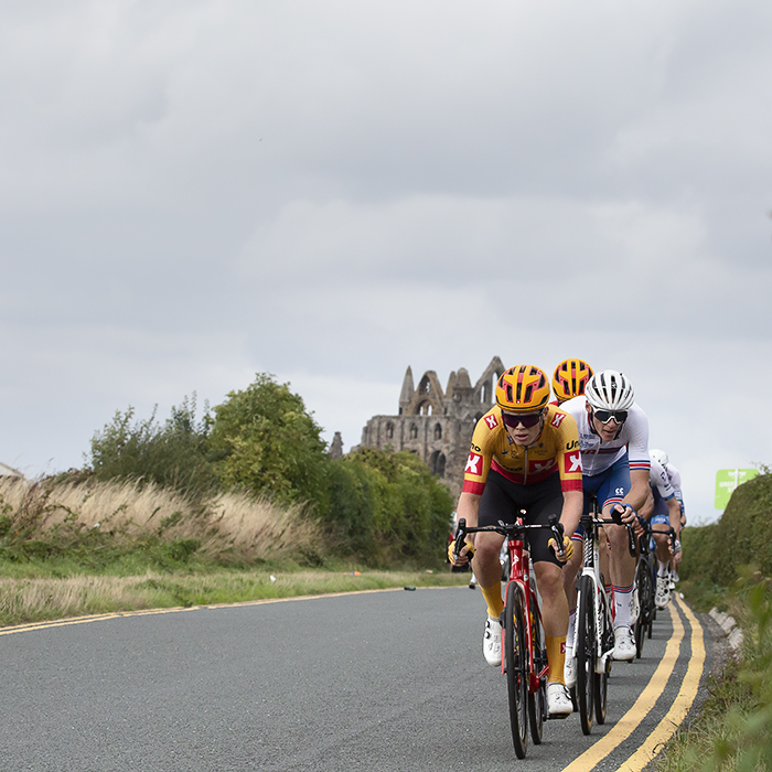 Tour of Britain 2022 - Uno-X Pro Cycling Team lead the breakaway with Whitby Abbey in the background