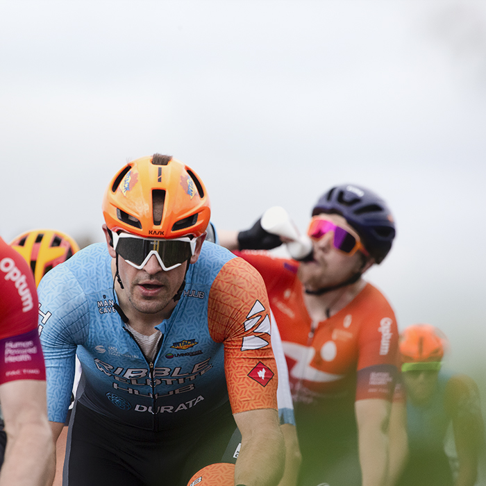 Tour of Britain 2022 - Ross Lamb of Ribble Weldtite Pro Cycling rides near Whitby Abbey while a rider drinks from a bidon behind him