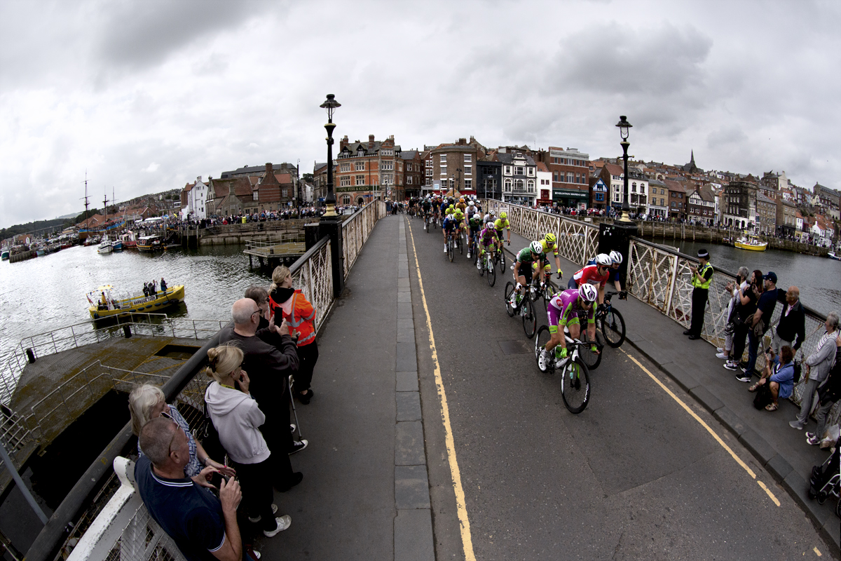 Tour of Britain 2022 - A wide view of Whitby Harbour as the riders cross the swing bridge