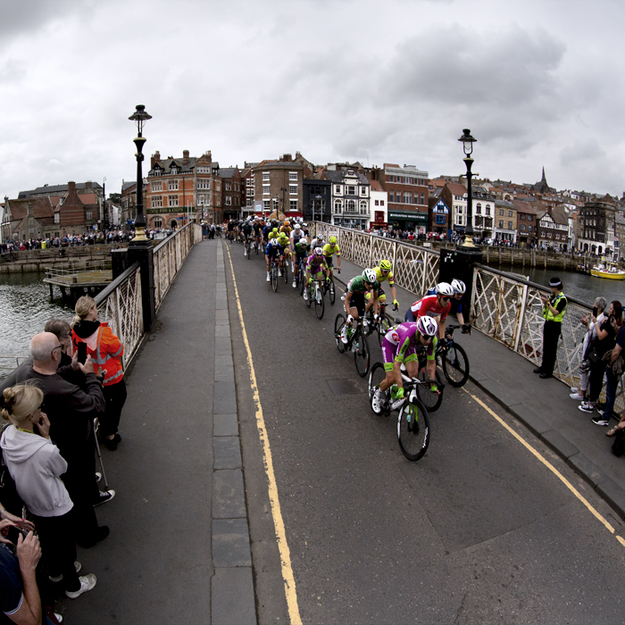 Tour of Britain 2022 - A wide view of Whitby Harbour as the riders cross the swing bridge