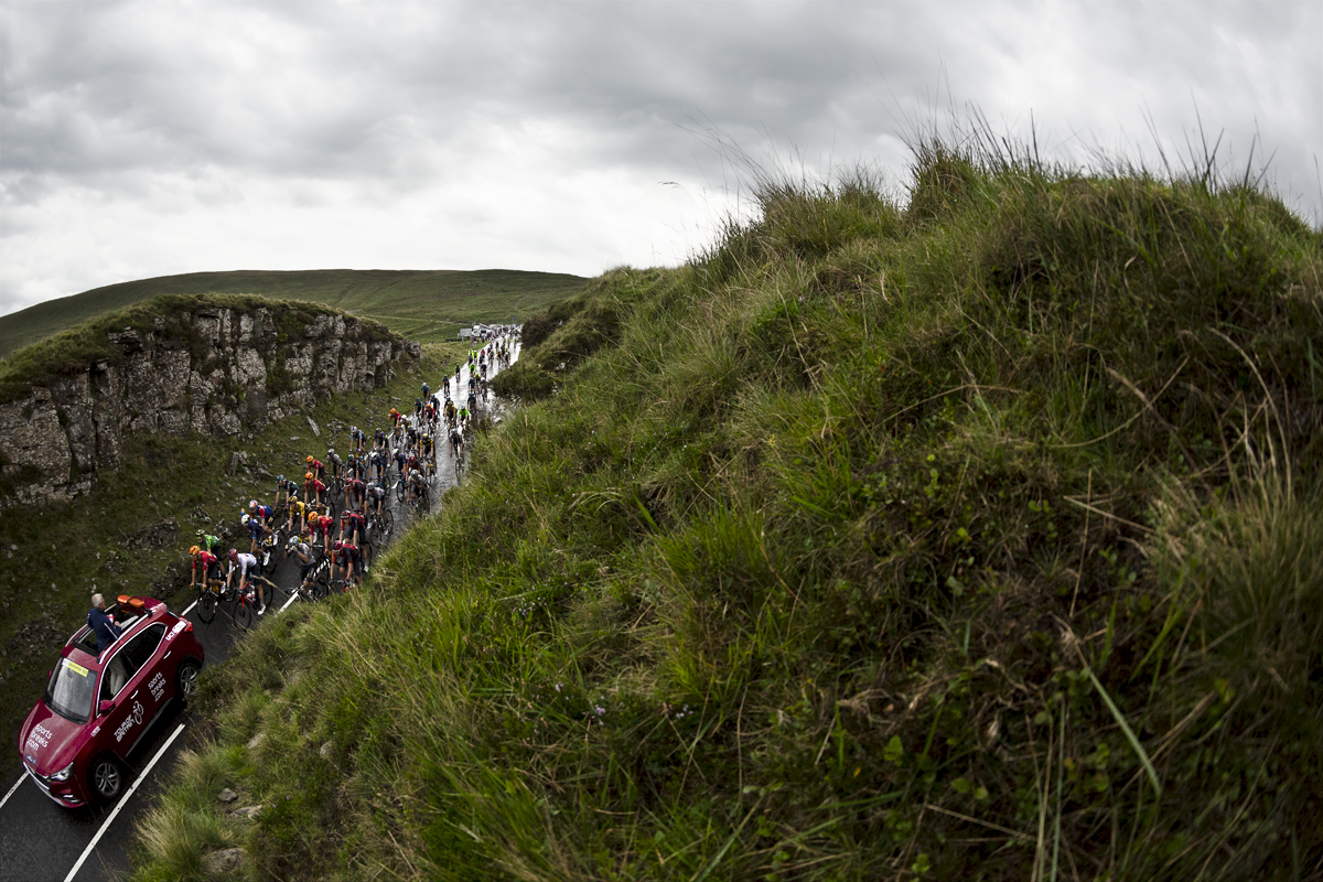 Tour of Britain 2023 - The peloton and race car on Bwlch Mountain