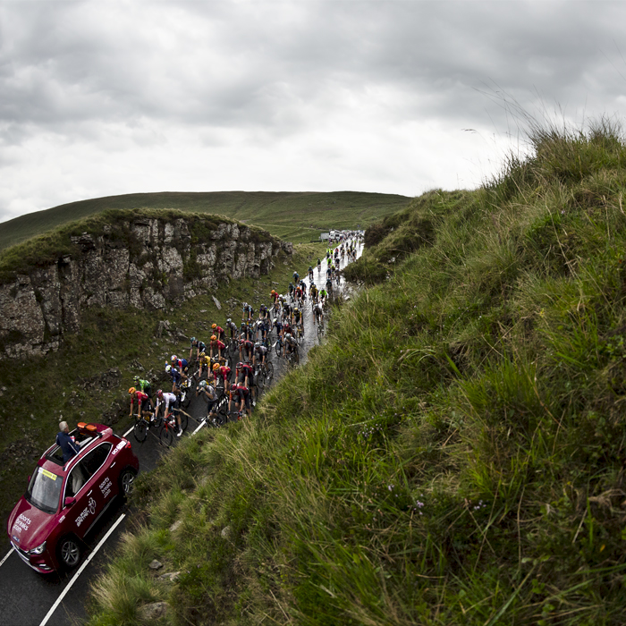 Tour of Britain 2023 - The peloton and race car on Bwlch Mountain