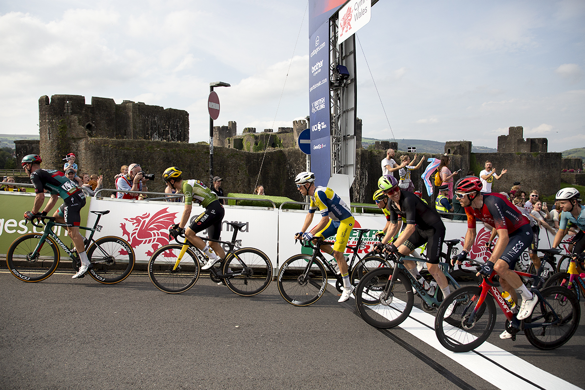 Tour of Britain 2023 - A group of riders cross the finish line for the first time with the castle in the background