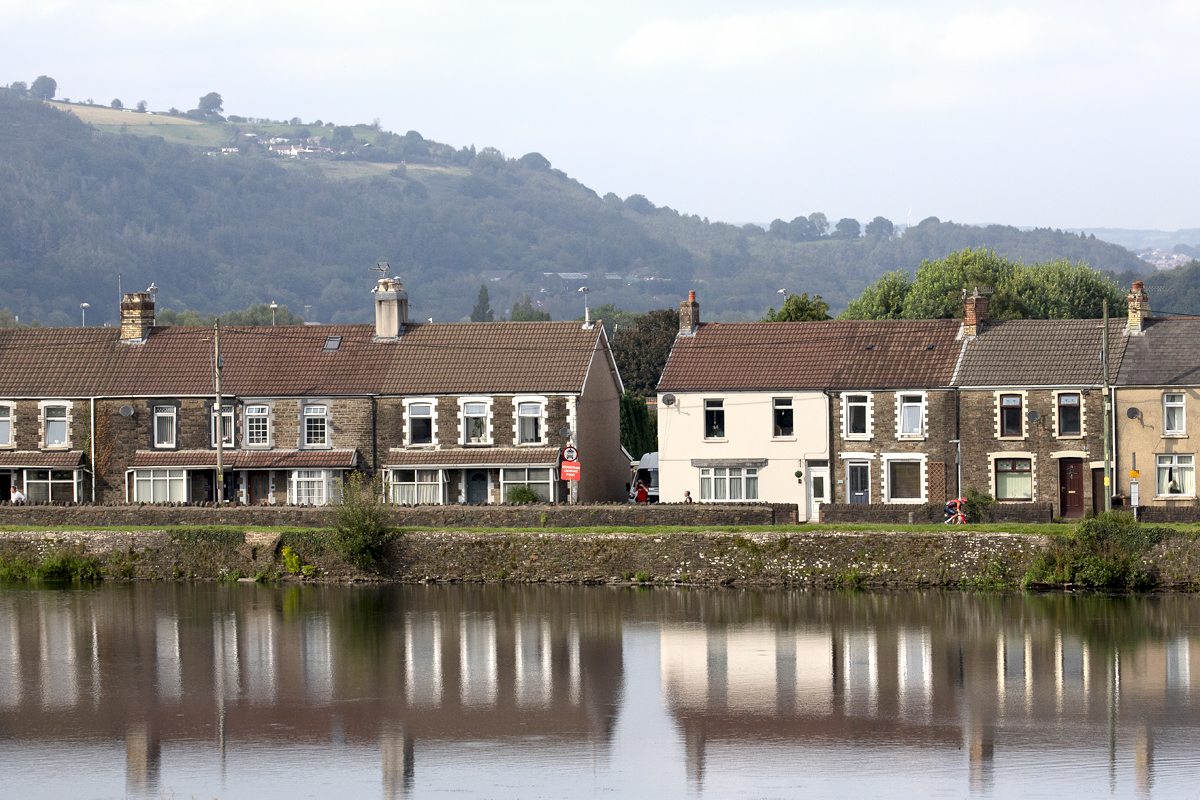 Tour of Britain 2023 - Carlos Rodríguez of INEOS Grenadiers passes a row of houses with the castle moat in the foreground