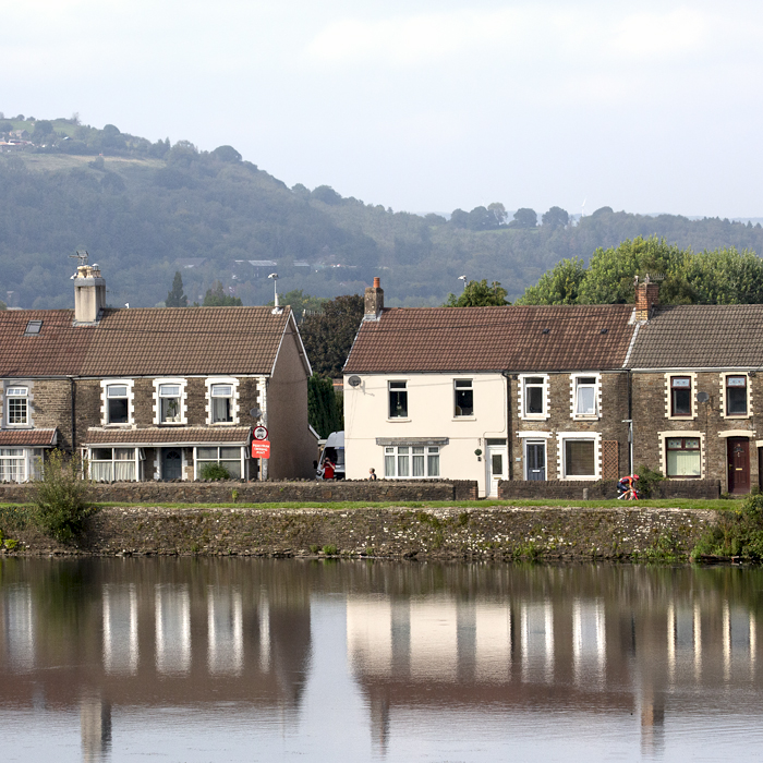 Tour of Britain 2023 - Carlos Rodríguez of INEOS Grenadiers passes a row of houses with the castle moat in the foreground