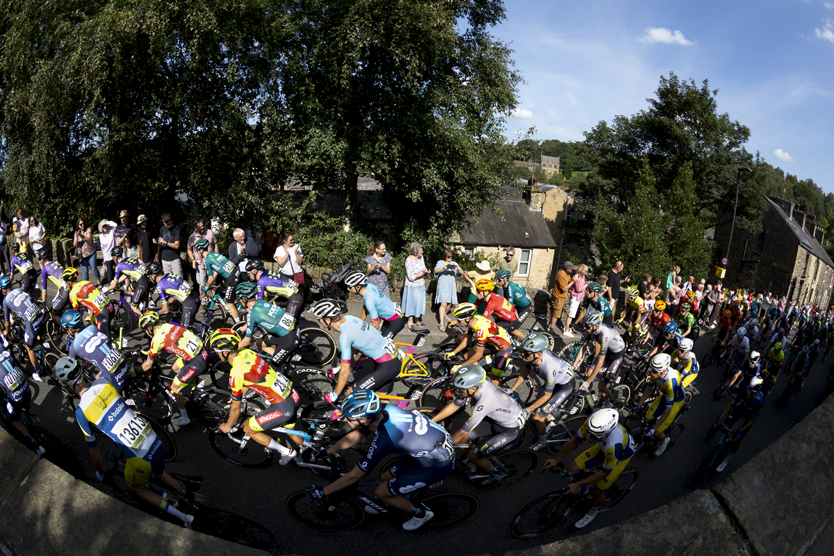 Tour of Britain 2023 - The peloton passes crowds on the way out of Delph