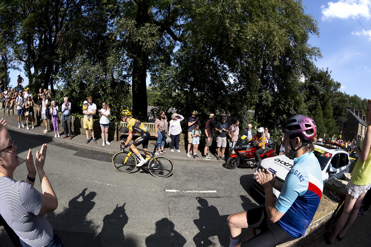 Tour of Britain 2023 - Steven Kruijswijk of Jumbo-Visma passes fans as a fan wearing cycling clothes sits on a wall applauding his progress