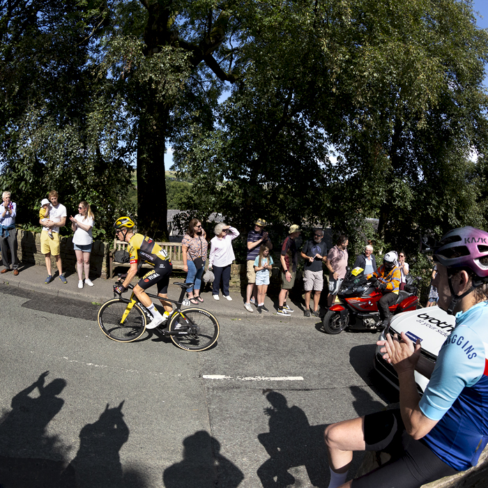 Tour of Britain 2023 - Steven Kruijswijk of Jumbo-Visma passes fans as a fan wearing cycling clothes sits on a wall applauding his progress