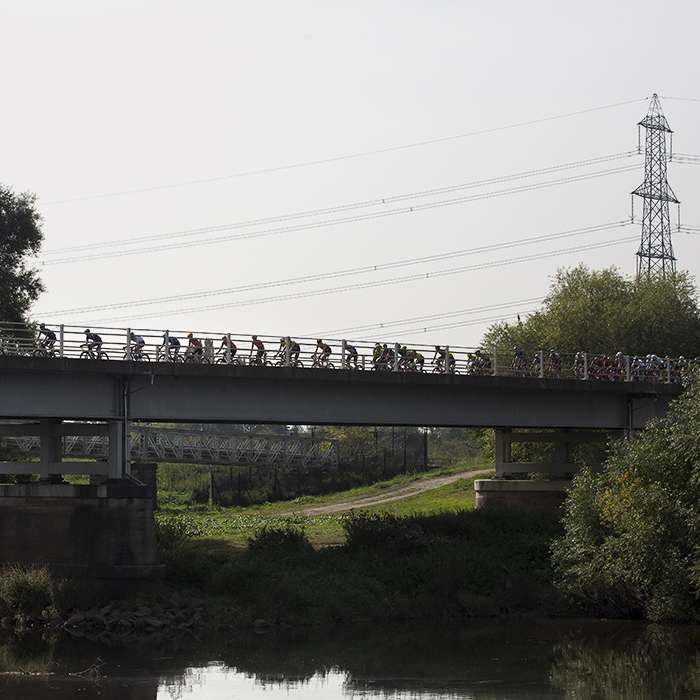 Tour of Britain 2023 - Riders silhouetted against the sky ride across Dunham Toll Bridge