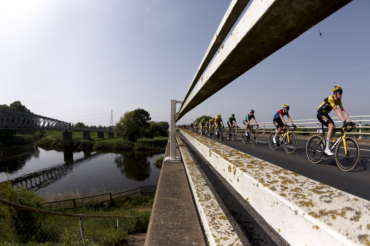 Tour of Britain 2023 - The peloton see through the barriers of the Dunham Toll Bridge