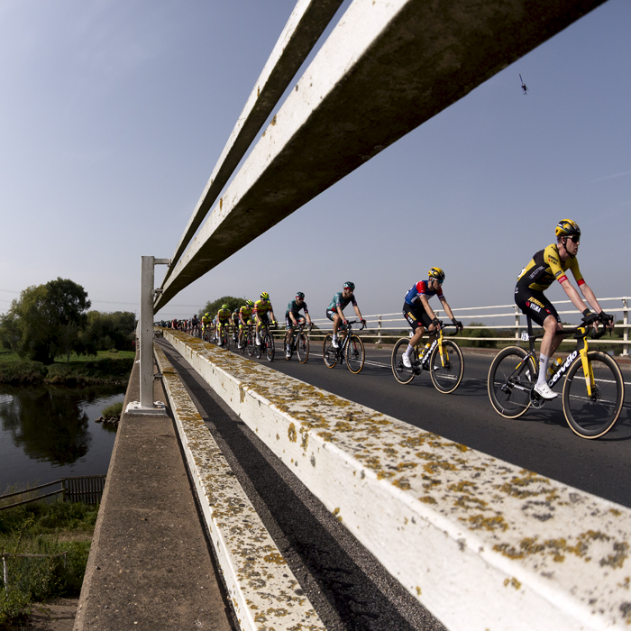 Tour of Britain 2023 - The peloton see through the barriers of the Dunham Toll Bridge