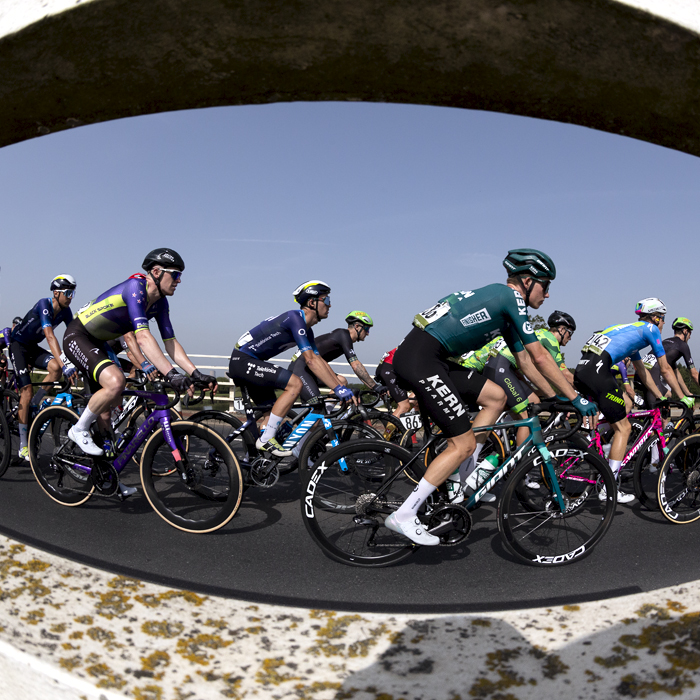 Tour of Britain 2023 - Riders from the side through the barriers at Dunham Toll Bridge