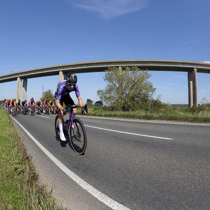 Tour of Britain 2023 - Ryan Christensen of Bolton Equities Black Spoke rides next to the River Orwell with the Orwell Bridge in the background