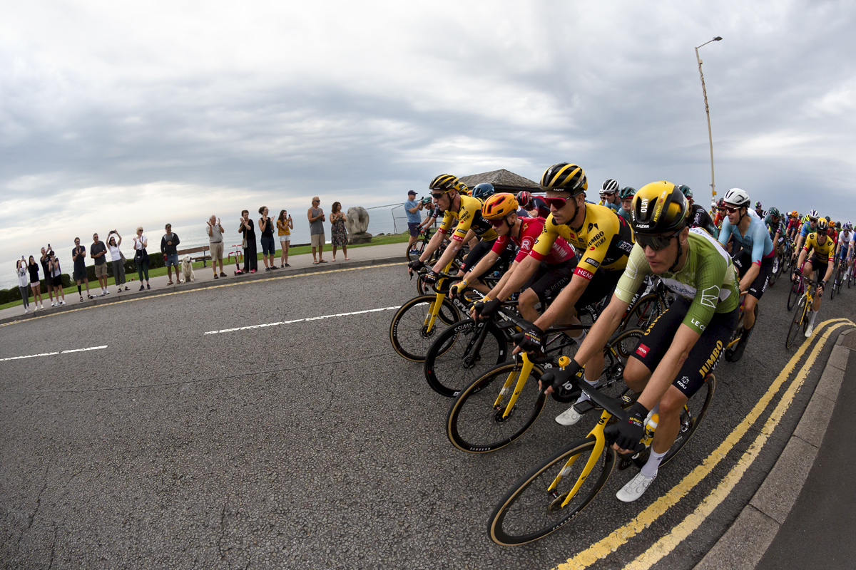 Tour of Britain 2023 - The peloton moves down the sea front in a block