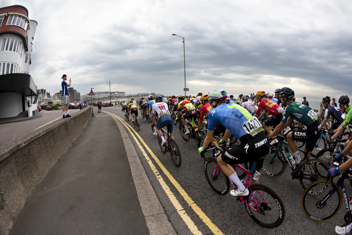 Tour of Britain 2023 - The peloton passes by down the sea front in Porthcawl