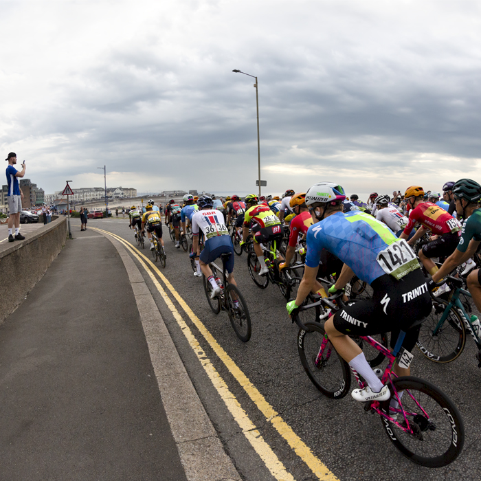 Tour of Britain 2023 - The peloton passes by down the sea front in Porthcawl