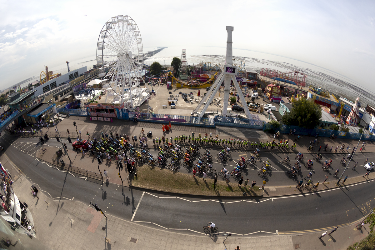 Tour of Britain 2023 - A panoramic shot of the race moving down the sea front