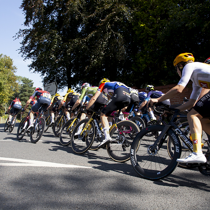 Tour of Britain 2023 - The peloton rounds a corner at speed