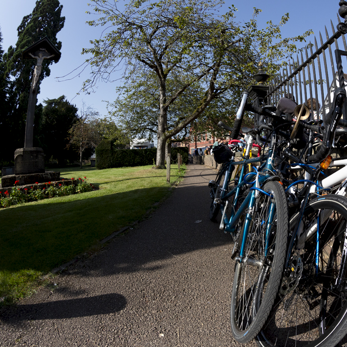 Tour of Britain 2023 - Spectators’ bikes are leant up against the railings at Tewkesbury Abbey