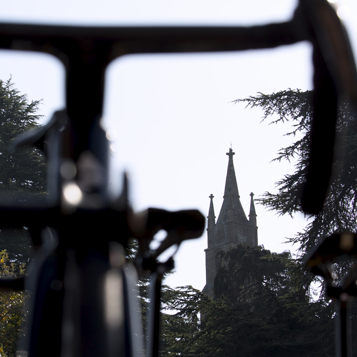 Tour of Britain 2023 - Tewkesbury Abbey with the handlebars of a bike in the foreground