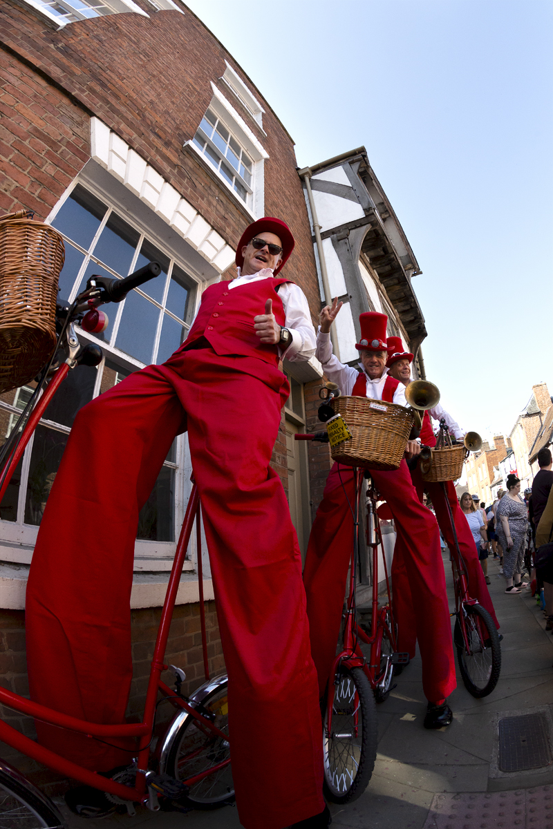 Tour of Britain 2023 - Members of the Steve Chaos Circus ride bikes in stilts before the start of the race