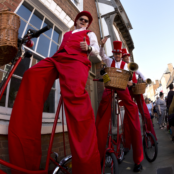 Tour of Britain 2023 - Members of the Steve Chaos Circus ride bikes in stilts before the start of the race