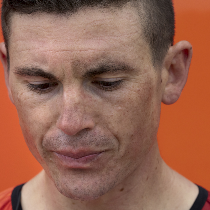 Tour of Britain 2024 - Ben Swift of INEOS Grenadiers, his face dirty from a days racing looks to the ground in front of the team bus