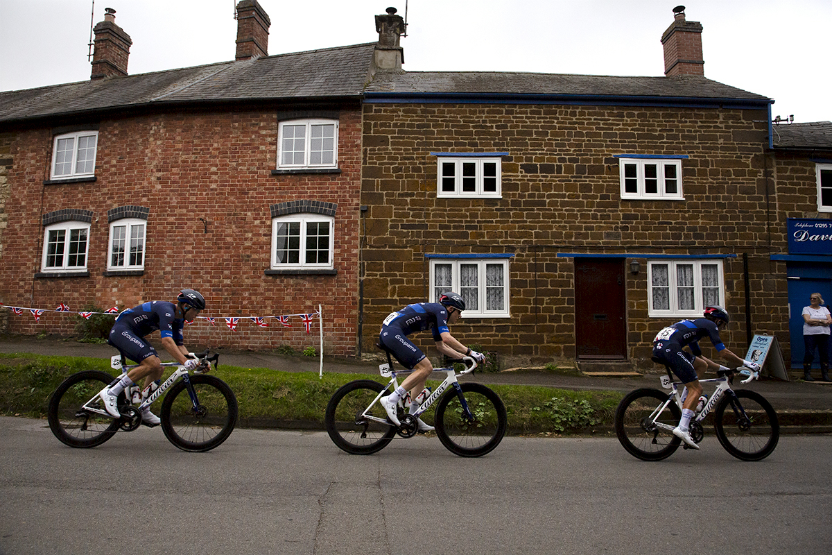 Tour of Britain 2024 - Riders from the Equipe continentale Groupama-FDJ team pass a row of cottages in Culworth