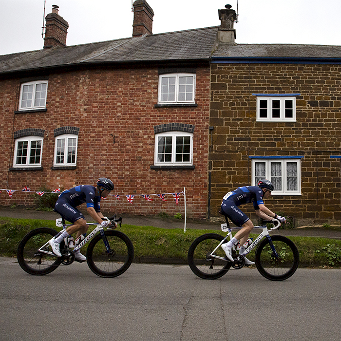 Tour of Britain 2024 - Riders from the Equipe continentale Groupama-FDJ team pass a row of cottages in Culworth