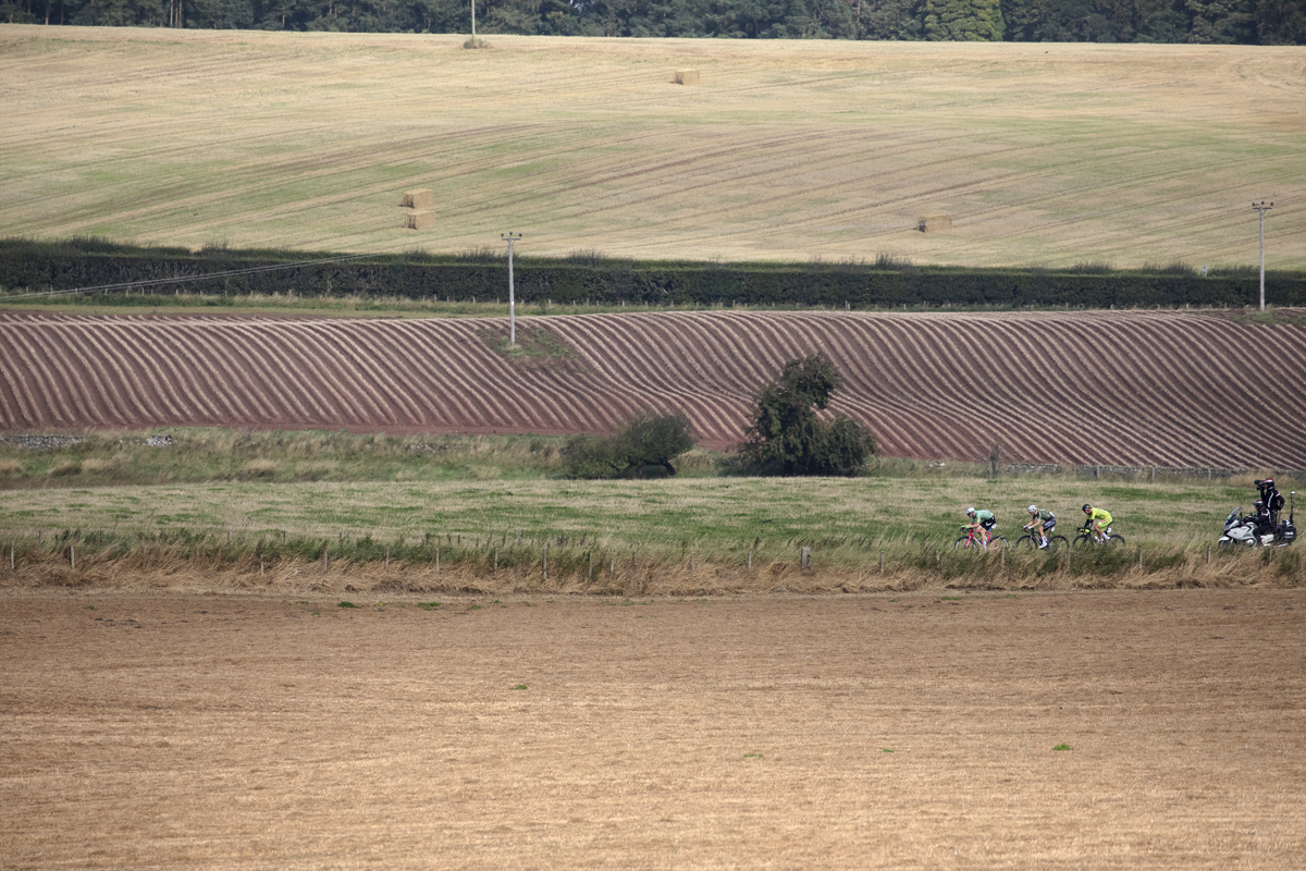 Tour of Britain 2024 - The breakaway followed closely by a camera bike traverses the arable fields of the Scottish Borders