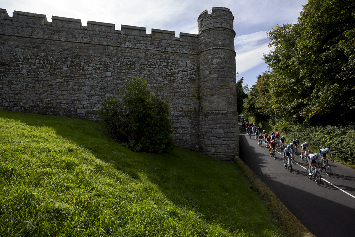 Tour of Britain 2024 - The peloton passes the battlements of Jedburgh Castle and Jail