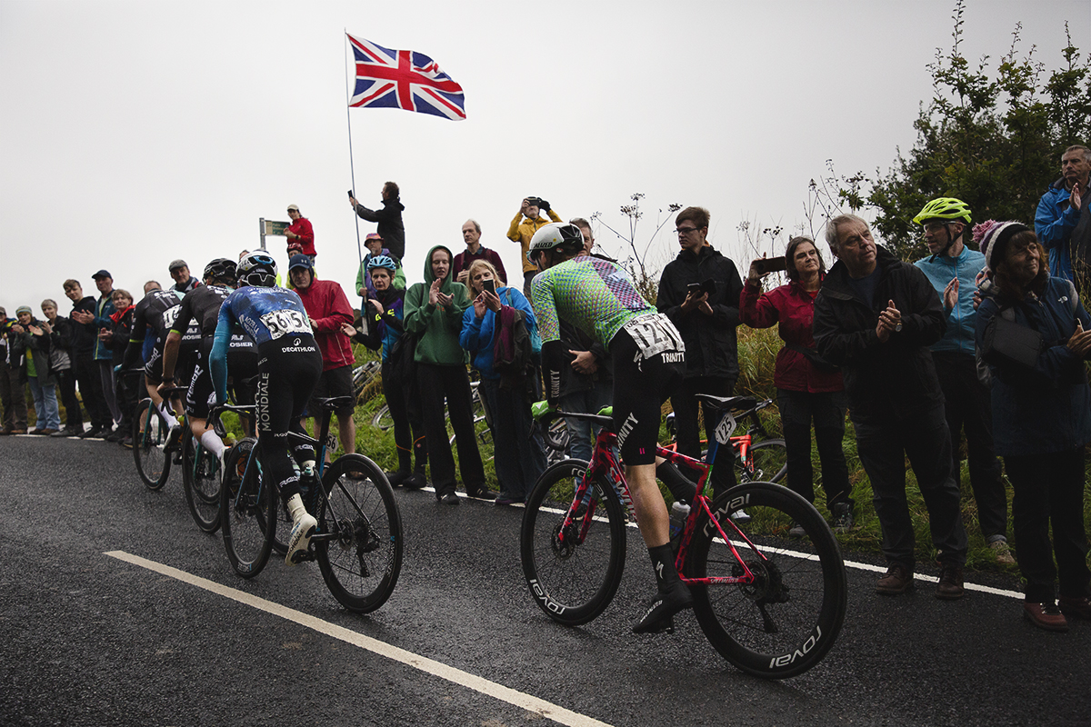 Tour of Britain 2024 - Riders pass fans waving a Union Jack on their way to the top of the Long Lane climb