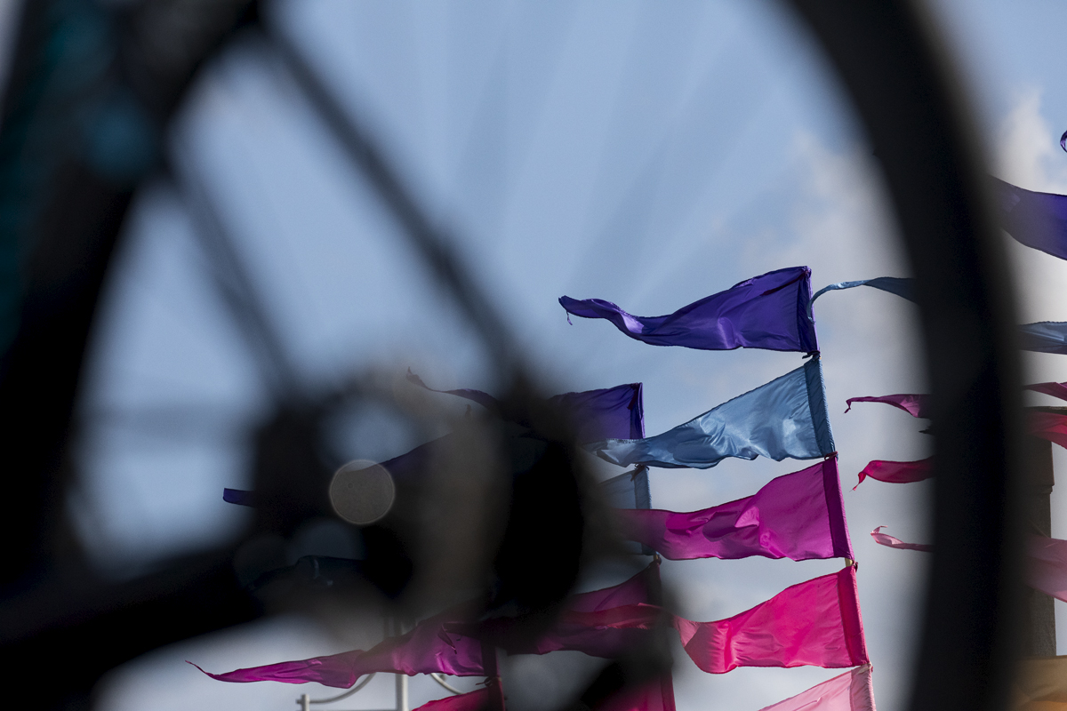 Tour of Britain 2024 - Flags blow in the breeze framed in a bike wheel