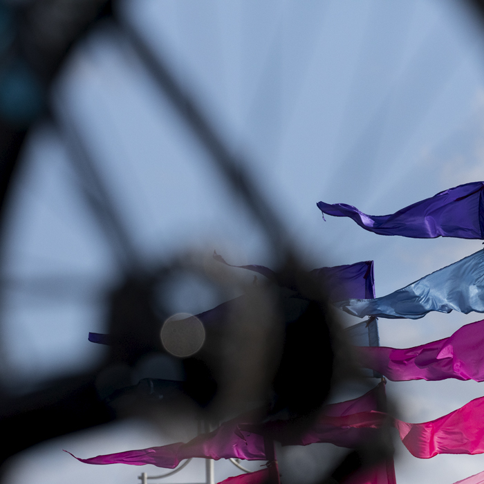 Tour of Britain 2024 - Flags blow in the breeze framed in a bike wheel