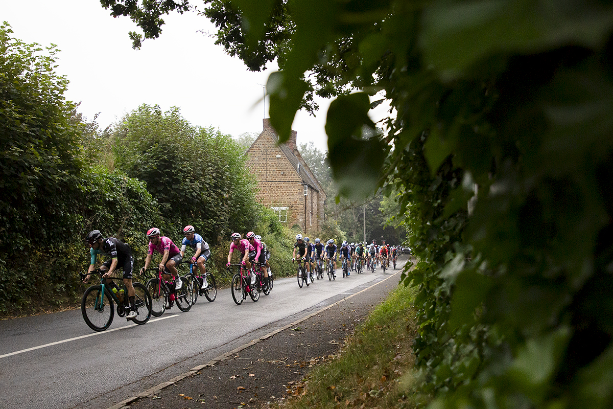 Tour of Britain 2024 - Riders pass a traditional stone building in the Northamptonshire countryside