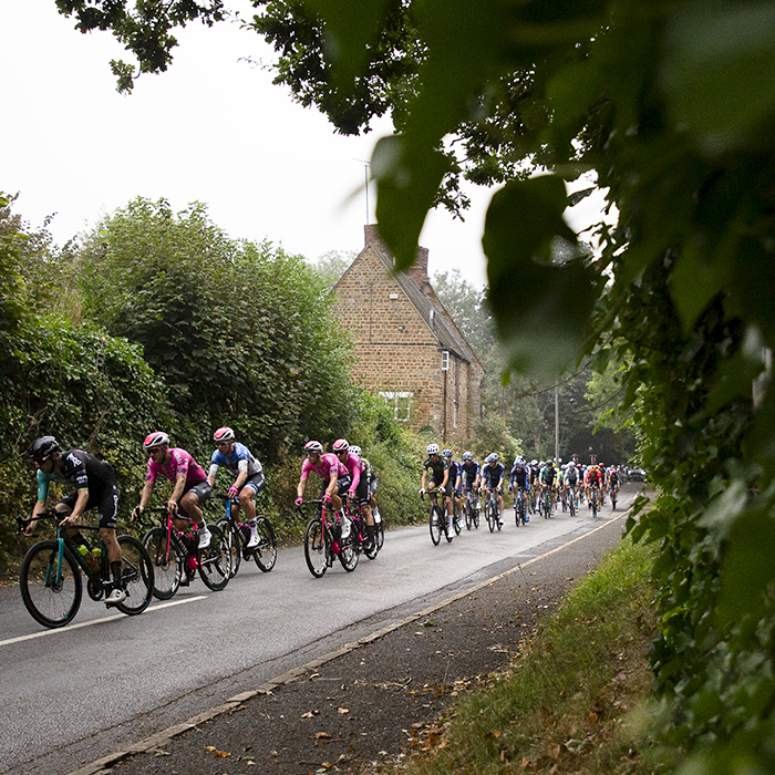 Tour of Britain 2024 - Riders pass a traditional stone building in the Northamptonshire countryside