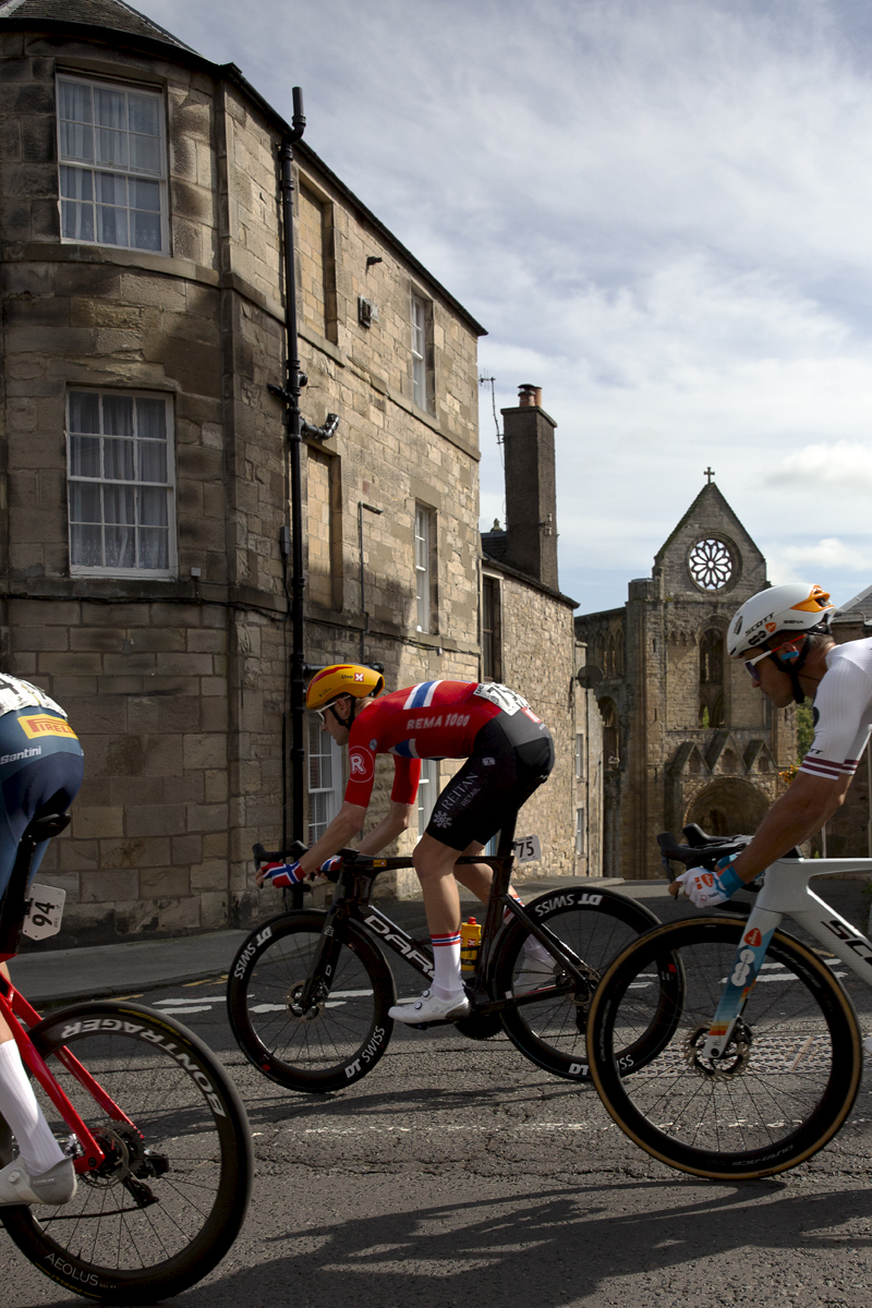 Tour of Britain 2024 - Markus Hoelgaard of UNO-X Mobility passes in front of Jedburgh Abbey