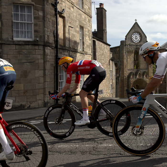 Tour of Britain 2024 - Markus Hoelgaard of UNO-X Mobility passes in front of Jedburgh Abbey