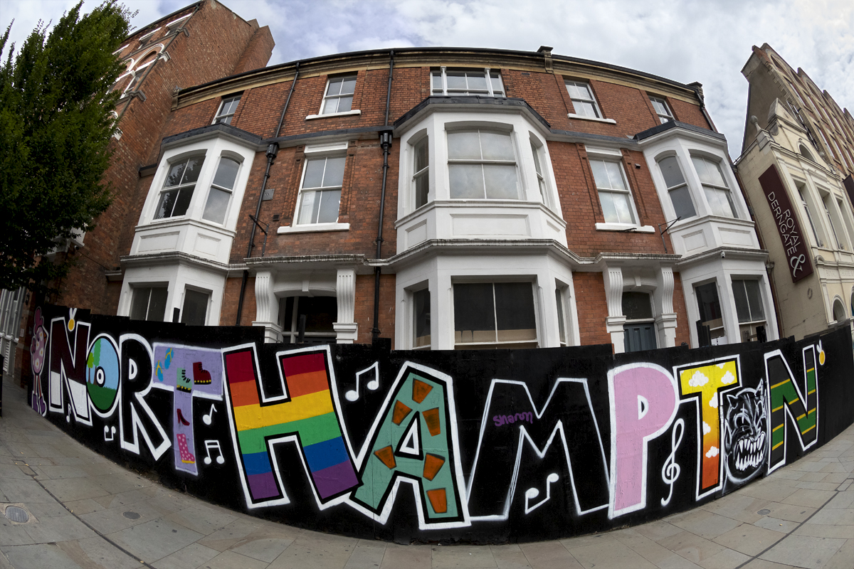 Tour of Britain 2024 - A hoarding with Northampton written on it in graffiti style