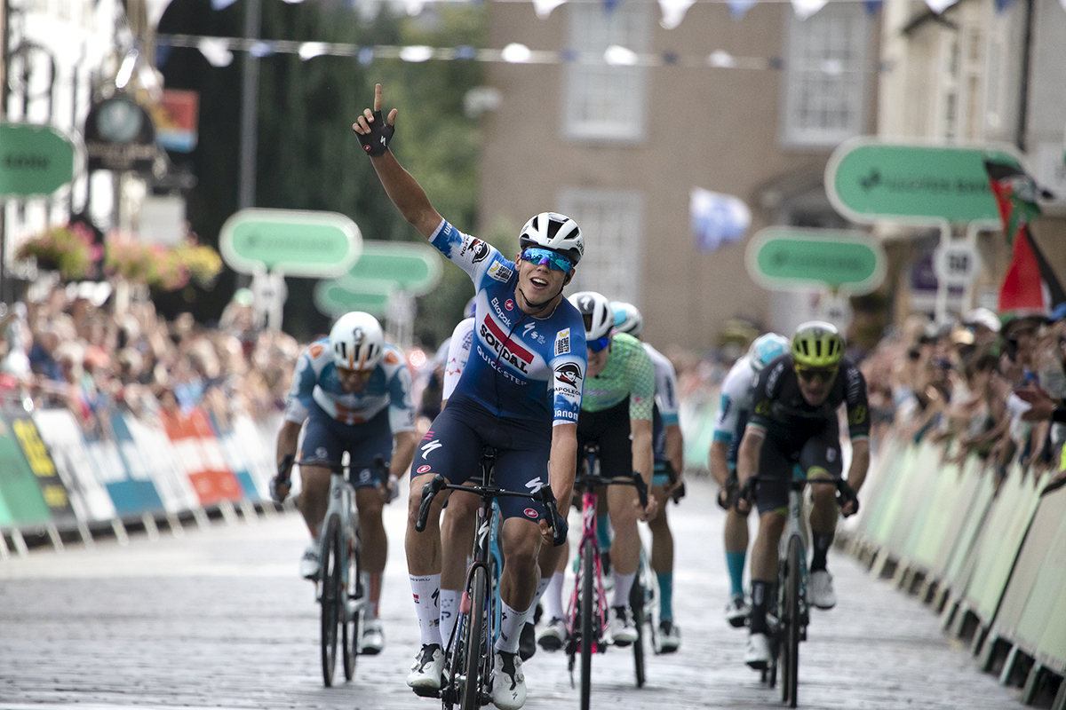 Tour of Britain 2024 - Paul Magnier raises his finger in the air as he crosses the finish line victorious in Kelso