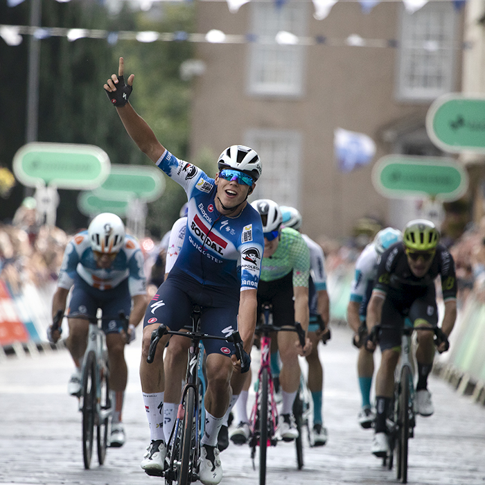 Tour of Britain 2024 - Paul Magnier raises his finger in the air as he crosses the finish line victorious in Kelso