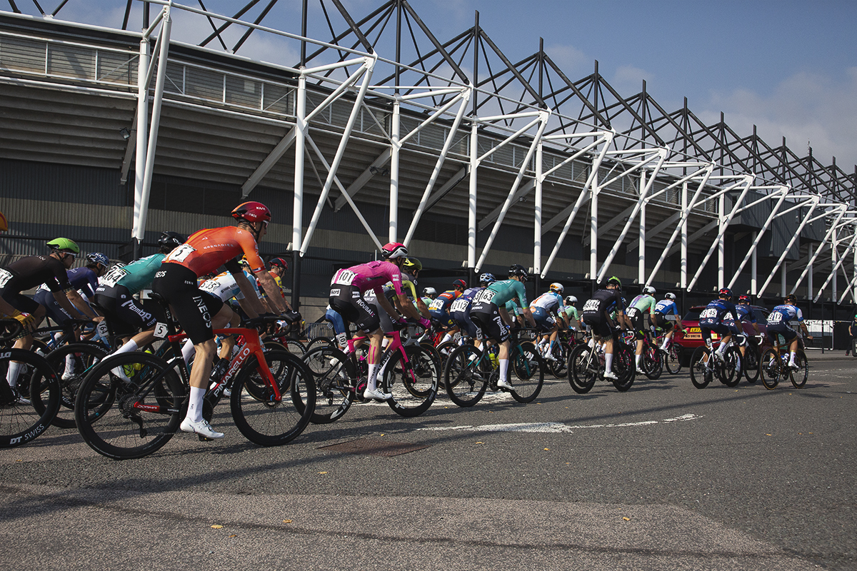 Tour of Britain 2024 - The riders roll out at the start of the race past Pride Park Stadium