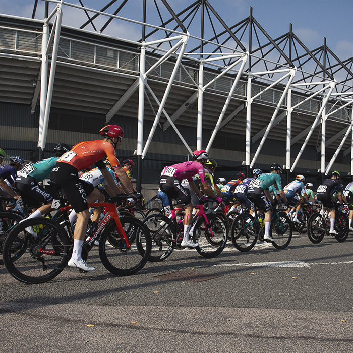 Tour of Britain 2024 - The riders roll out at the start of the race past Pride Park Stadium